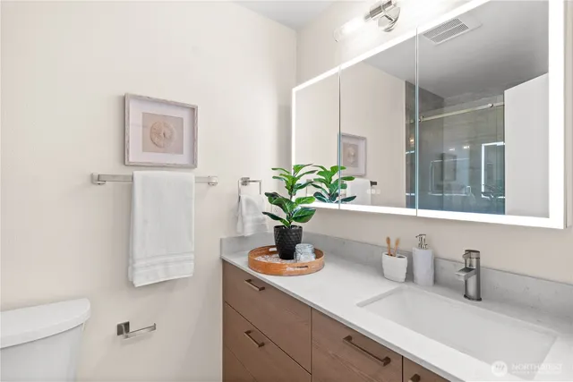 a bathroom with a sink a toilet and mirror