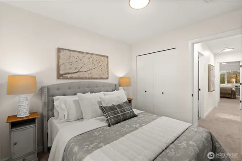 a bedroom with a bed and a lamp on dresser