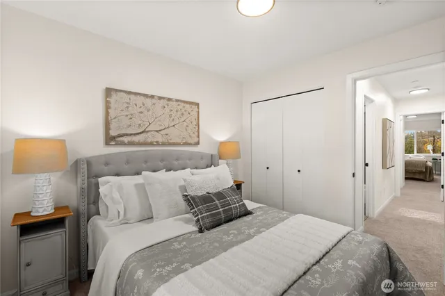 a bedroom with a bed and a lamp on dresser