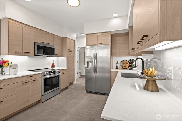 a kitchen with stainless steel appliances granite countertop a sink and a stove