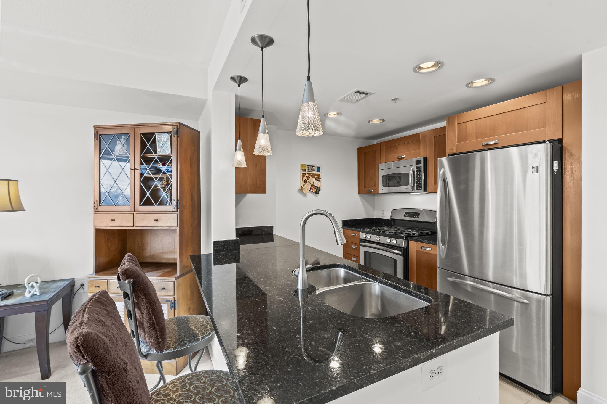 2451 Midtown Avenue, Unit 1413 Alexandria, VA 22303 - Photo 8 of 19 a kitchen with stainless steel appliances granite countertop a sink refrigerator and cabinets