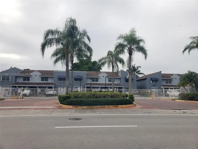 a front view of multiple houses with a yard
