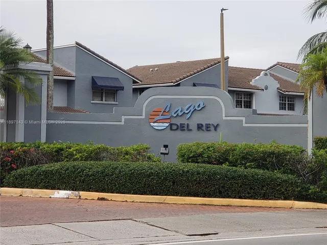 a front view of a house with a yard and potted plants