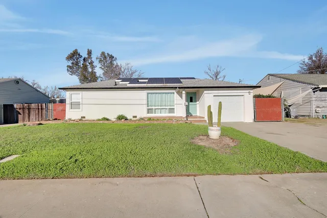 a front view of a house with a garden and yard