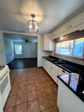 a kitchen with stainless steel appliances granite countertop a stove a sink and a microwave