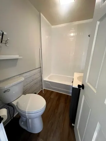 a white toilet sitting next to a bathroom sink and tub