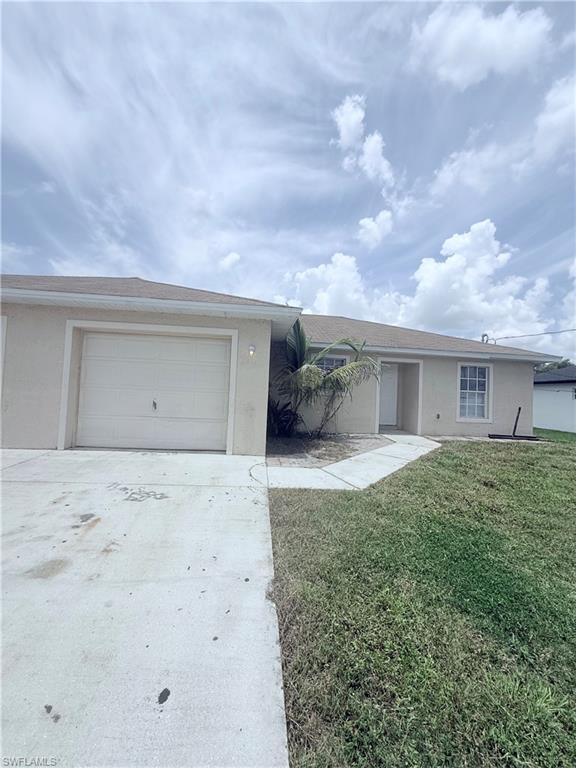 5212 30th Street Southwest Lehigh Acres, FL 33973 - Photo 3 of 15 a front view of a house with a yard and garage