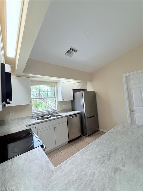 5212 30th Street Southwest Lehigh Acres, FL 33973 - Photo 5 of 15 a kitchen with a refrigerator and a sink