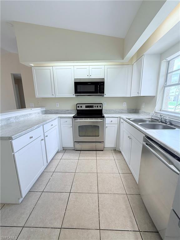 5212 30th Street Southwest Lehigh Acres, FL 33973 - Photo 6 of 15 a kitchen with stainless steel appliances granite countertop a stove a sink and a microwave