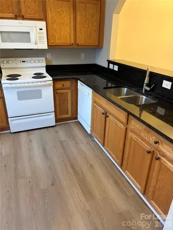 a kitchen with granite countertop a sink and a stove