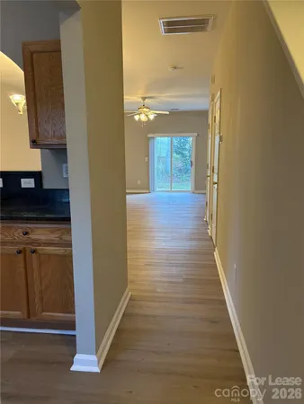 a view of a hallway to a house and wooden floor