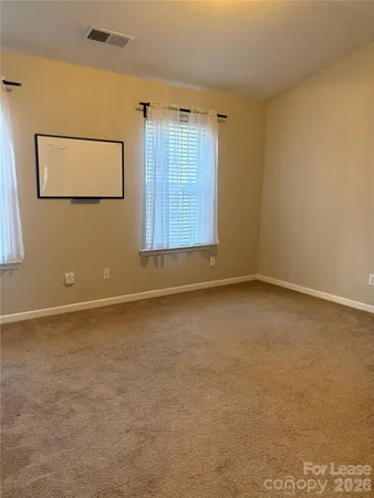 an empty room with windows and cabinet