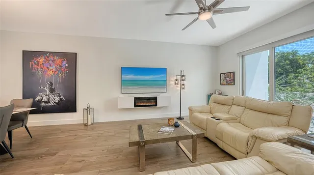 a very nice looking dining room with kitchen island a chandelier and wooden floor