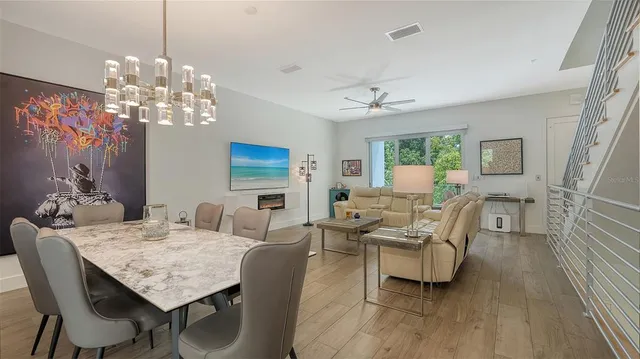 a view of a dining room with furniture a chandelier and wooden floor