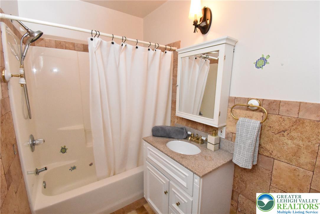 424 Grape Street Whitehall, PA 18052 - Photo 48 of 56 This bathroom features a shower and vanity with a well-lit mirror, offering both comfort and practicality.