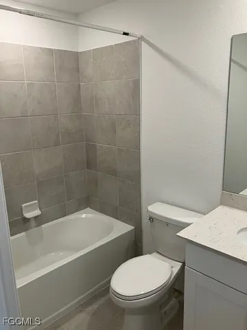 a white toilet and tub sitting next to a bathroom sink