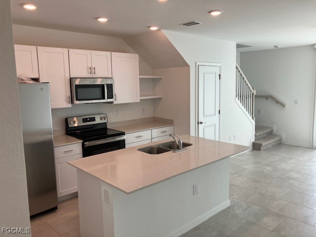 14309 Oviedo Place Fort Myers, FL 33905 - Photo 2 of 30 a kitchen with kitchen island a sink appliances and cabinets