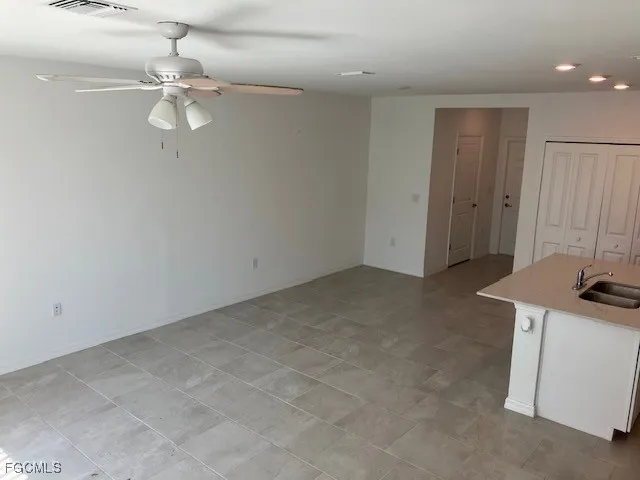 an empty room with a mirror and a fan