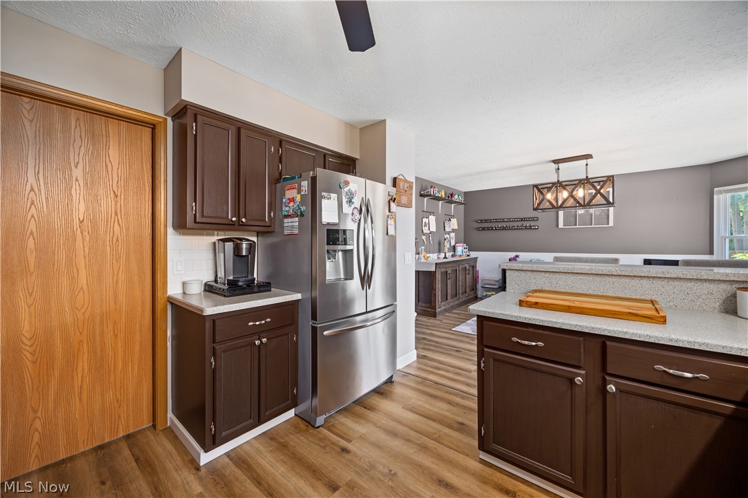 684 Guilford Road Vermilion, OH 44089 - Photo 14 of 37 Kitchen with stainless steel fridge, ceiling fan, backsplash, and light hardwood / wood-style floors