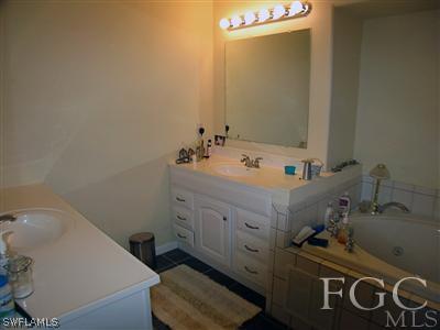 10683 Holly Road Bokeelia, FL 33922 - Photo 6 of 10 a bathroom with a sink and a mirror