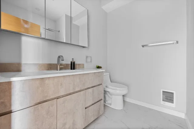 a kitchen with a sink a toilet and cabinets