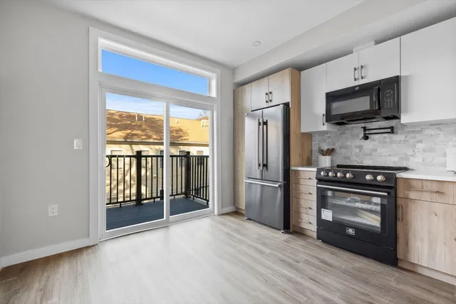 a kitchen with stainless steel appliances a stove microwave and a refrigerator