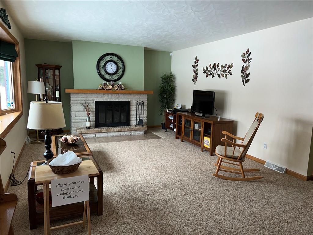 Entering the home, you will find a cozy living room with a wood burning fireplace with lots of natural sunlight.