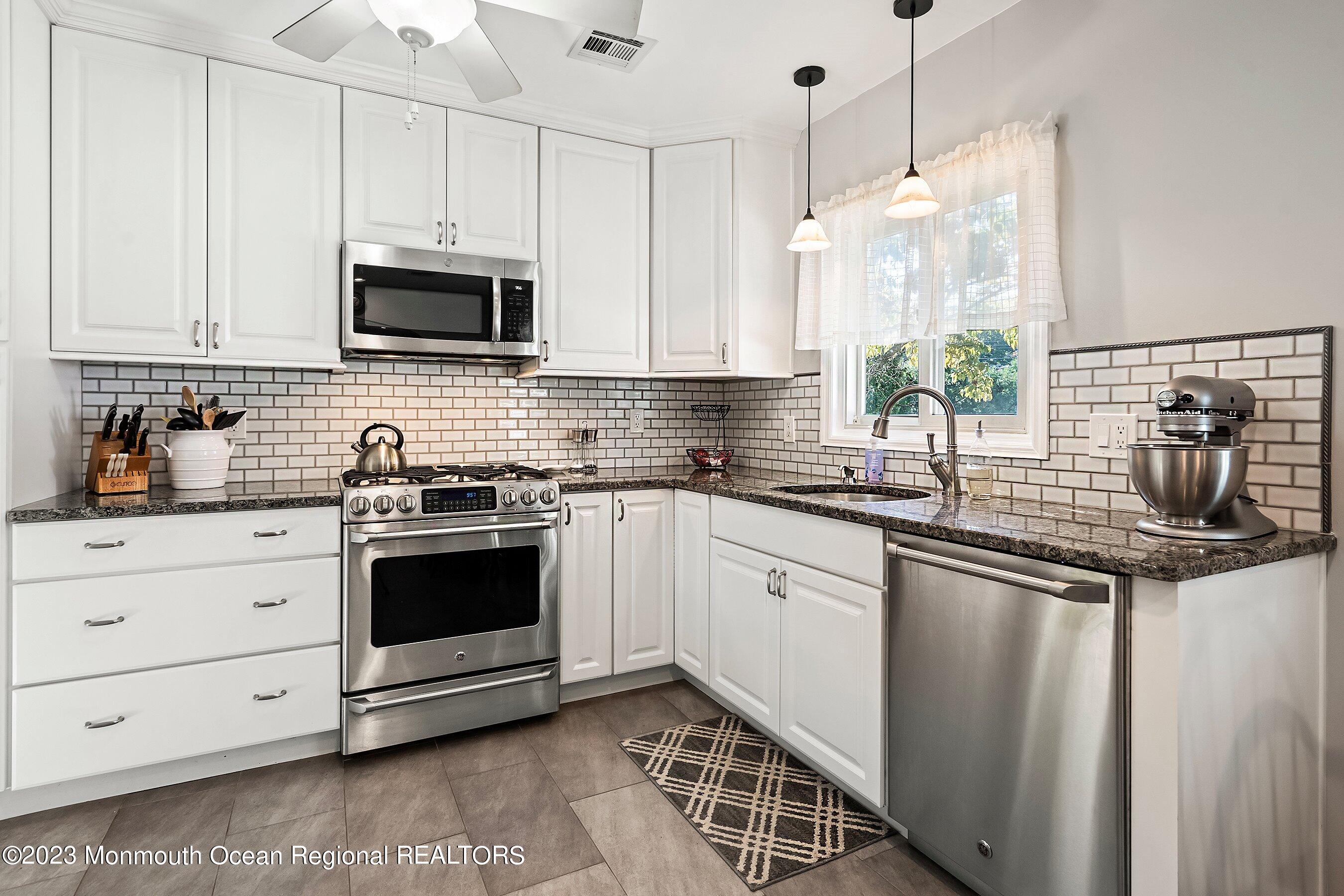 154 Adelphia Road Farmingdale, NJ 07727 - Photo 14 of 34 a kitchen with stainless steel appliances granite countertop a sink a stove and a microwave
