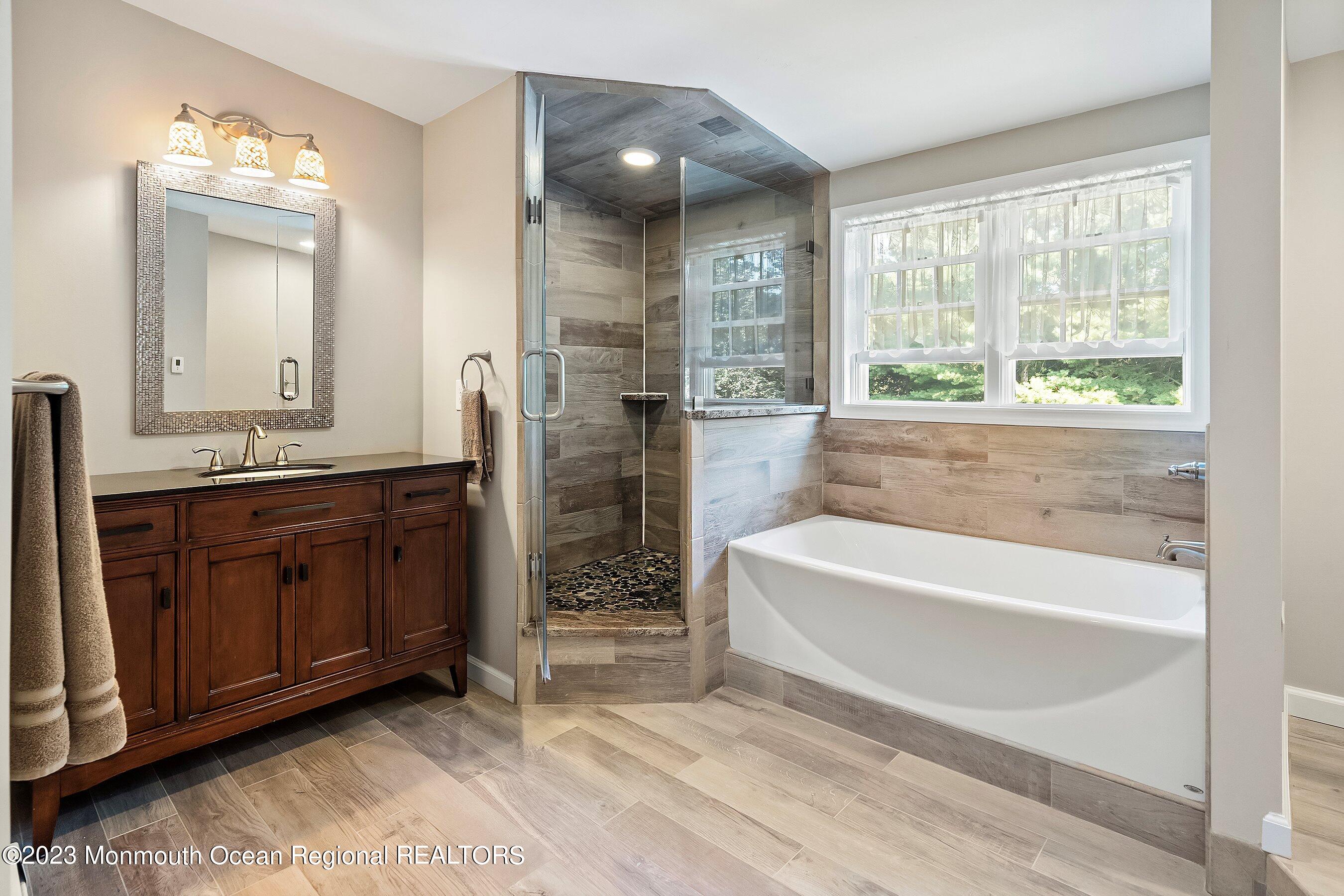 154 Adelphia Road Farmingdale, NJ 07727 - Photo 23 of 34 a spacious bathroom with a tub sink and mirror