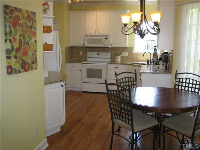 512 South Allen Road Wake Forest, NC 27587 - Photo 5 of 12 Bright & light kitchen, granite countertops, tiled backsplash, hardwood floors & bayed breakfast nook.