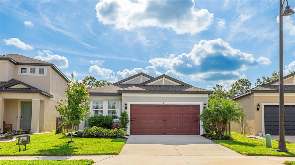 a front view of a house with a yard and potted plants