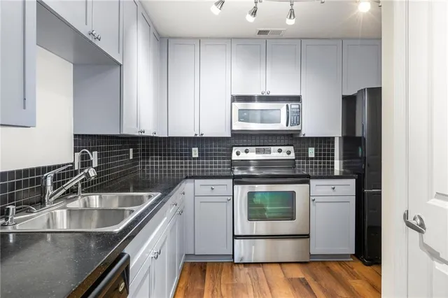 a kitchen with stainless steel appliances granite countertop a sink stove and refrigerator