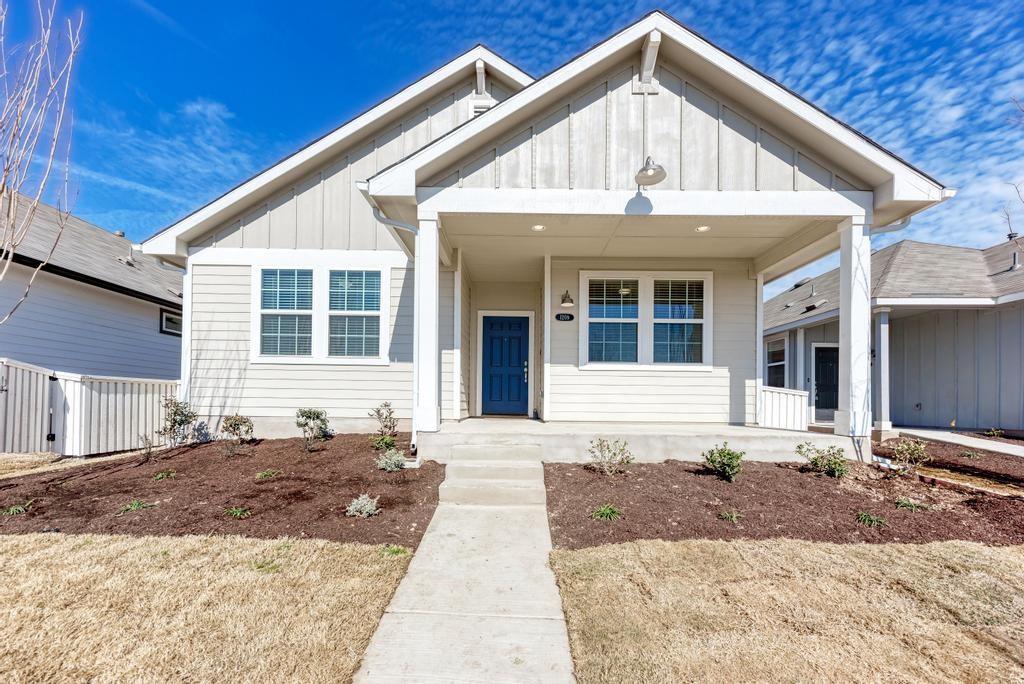 1209 Goforth Road Kyle, TX 78640 - Photo 2 of 32 A charming cottage-style residence greets with a welcoming covered front porch and a bold blue entry door.