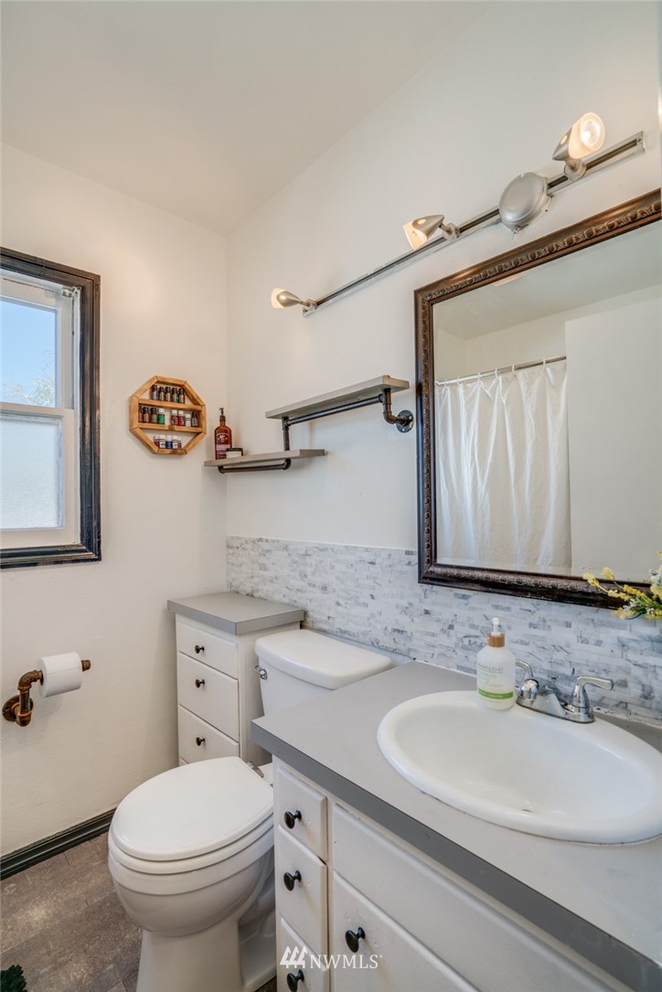1036 Tyler Street Wenatchee, WA 98801 - Photo 16 of 29 a bathroom with a granite countertop toilet sink and mirror