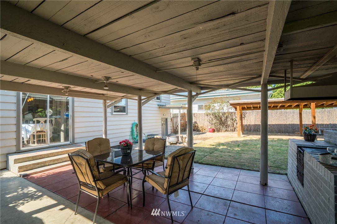 1036 Tyler Street Wenatchee, WA 98801 - Photo 23 of 29 a view of a patio with table and chairs and floor to ceiling window with wooden floor