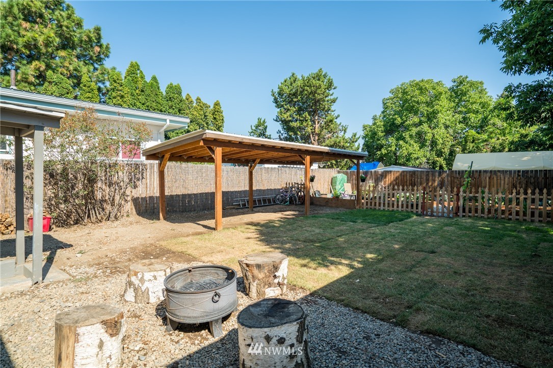 1036 Tyler Street Wenatchee, WA 98801 - Photo 25 of 29 a backyard of a house with wooden floor table and chairs