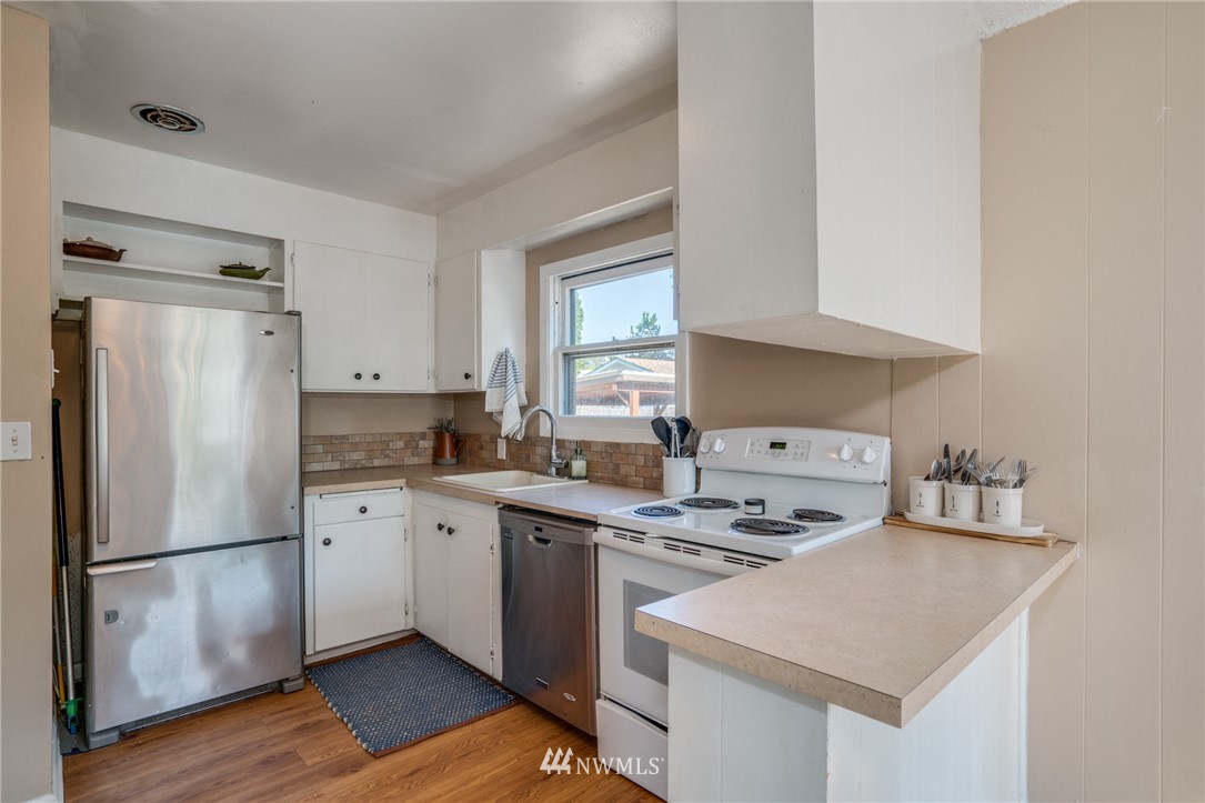 1036 Tyler Street Wenatchee, WA 98801 - Photo 10 of 29 a kitchen with stainless steel appliances a sink a stove a refrigerator and cabinets