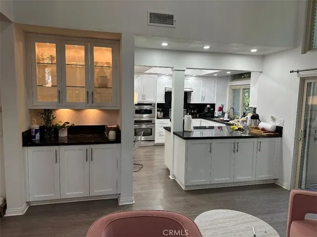 a kitchen with granite countertop a stove and white cabinets