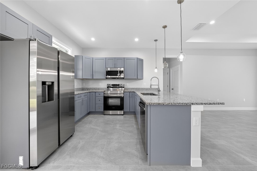 2864 68th Avenue Northeast Naples, FL 34120 - Photo 19 of 47 a kitchen with kitchen island a counter top space stainless steel appliances and cabinets
