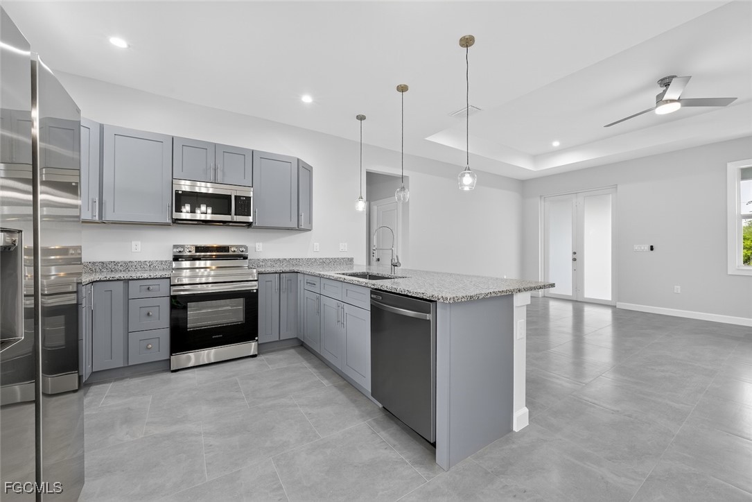 2864 68th Avenue Northeast Naples, FL 34120 - Photo 20 of 47 a kitchen with kitchen island a stove a sink and a microwave