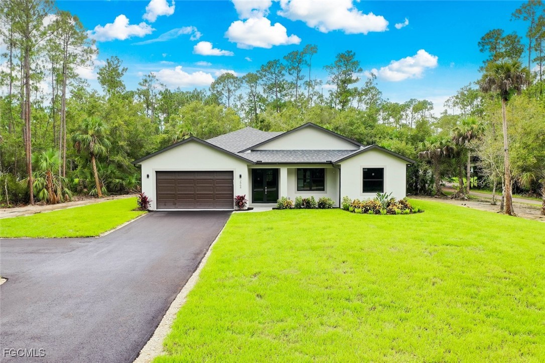 2864 68th Avenue Northeast Naples, FL 34120 - Photo 2 of 47 a front view of a house with yard and green space