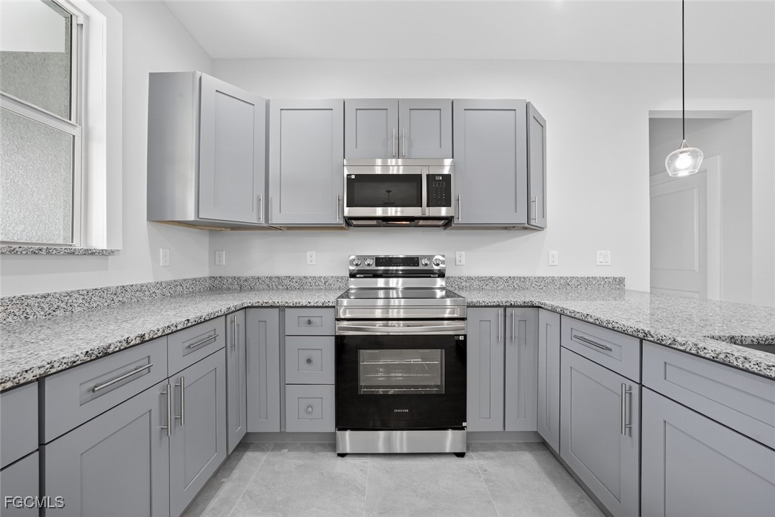 2864 68th Avenue Northeast Naples, FL 34120 - Photo 21 of 47 a kitchen with granite countertop white cabinets and stainless steel appliances