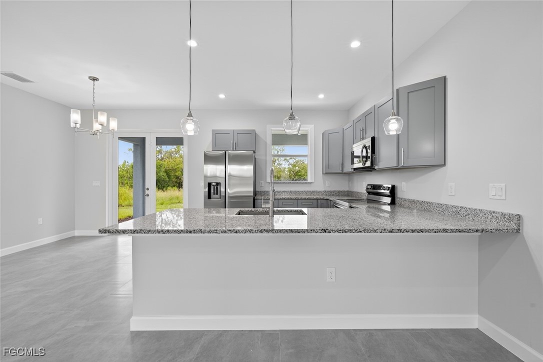 2864 68th Avenue Northeast Naples, FL 34120 - Photo 24 of 47 a large kitchen with granite countertop a sink a counter top space and stainless steel appliances