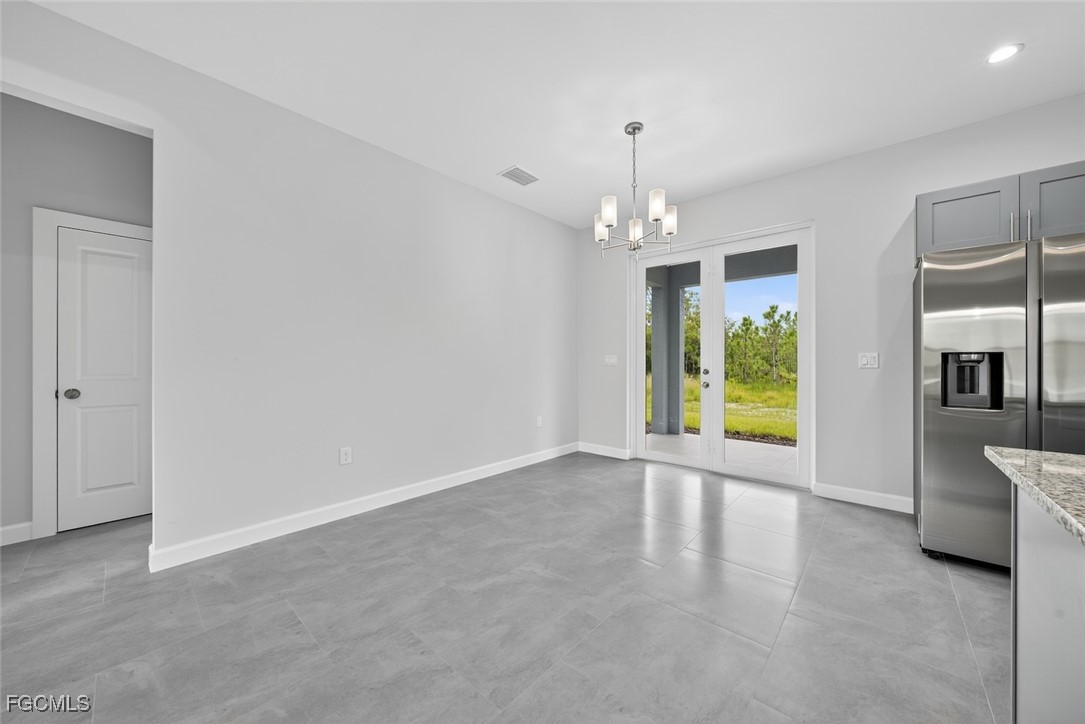 2864 68th Avenue Northeast Naples, FL 34120 - Photo 28 of 47 an empty room with chandelier and windows