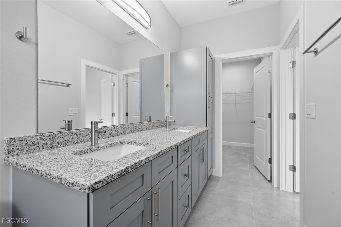 2864 68th Avenue Northeast Naples, FL 34120 - Photo 36 of 47 a bathroom with a granite countertop sink and a mirror
