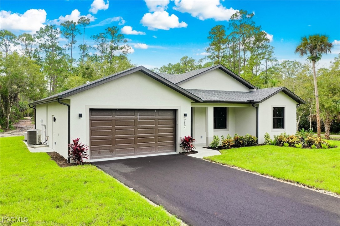 2864 68th Avenue Northeast Naples, FL 34120 - Photo 6 of 47 a front view of a house with a yard and garage