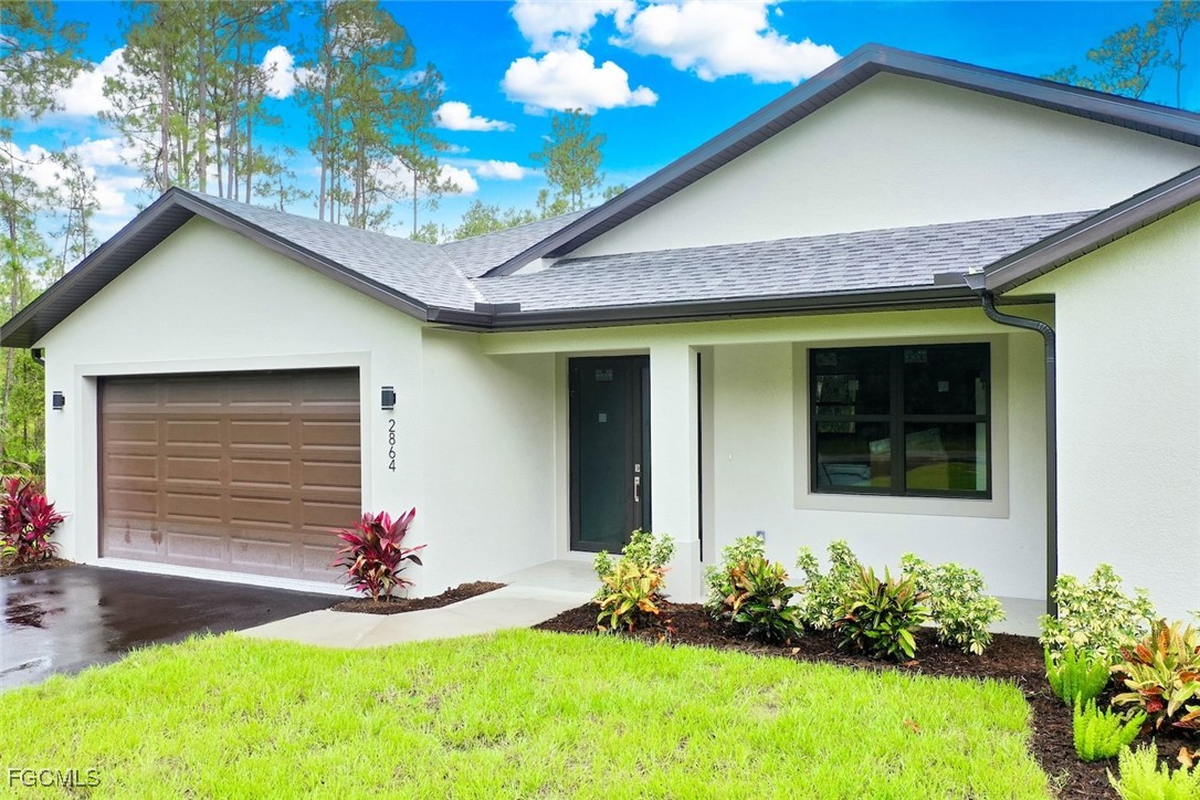 2864 68th Avenue Northeast Naples, FL 34120 - Photo 9 of 47 a front view of a house with a yard and garage