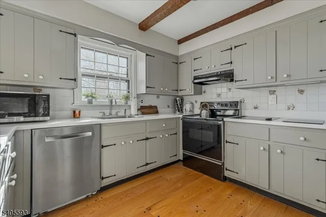 a kitchen with cabinets stainless steel appliances and a window