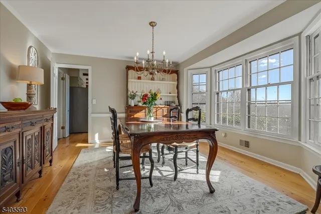 a dining room with furniture a chandelier and wooden floor