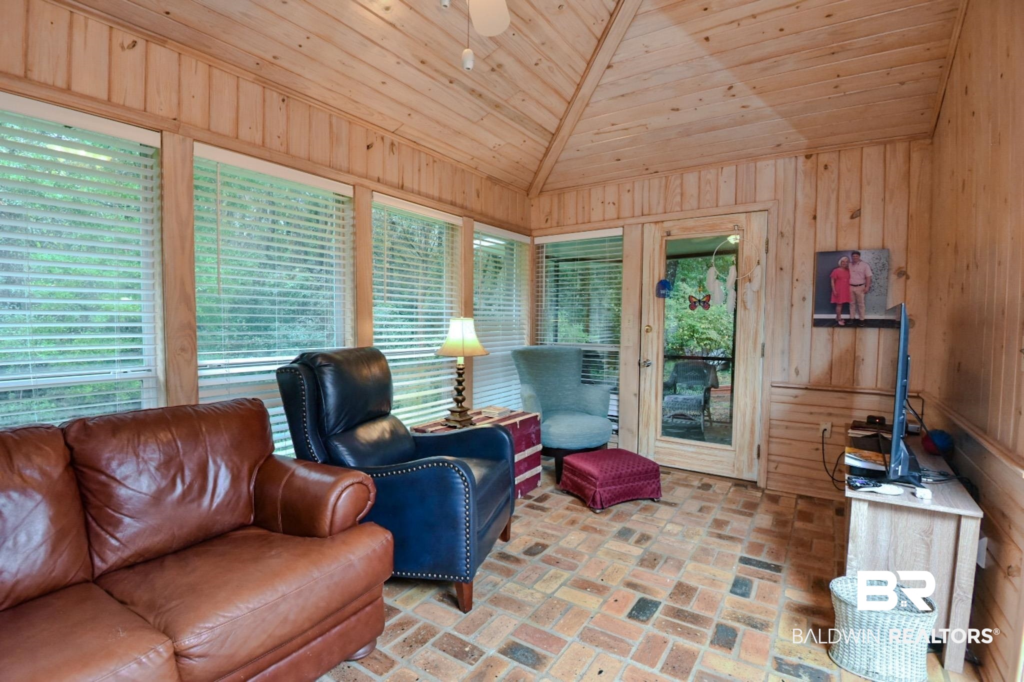 90 Paddock Drive Fairhope, AL 36532 - Photo 13 of 23 Living area with brick floors, wood walls, wood ceiling, and lofted ceiling
